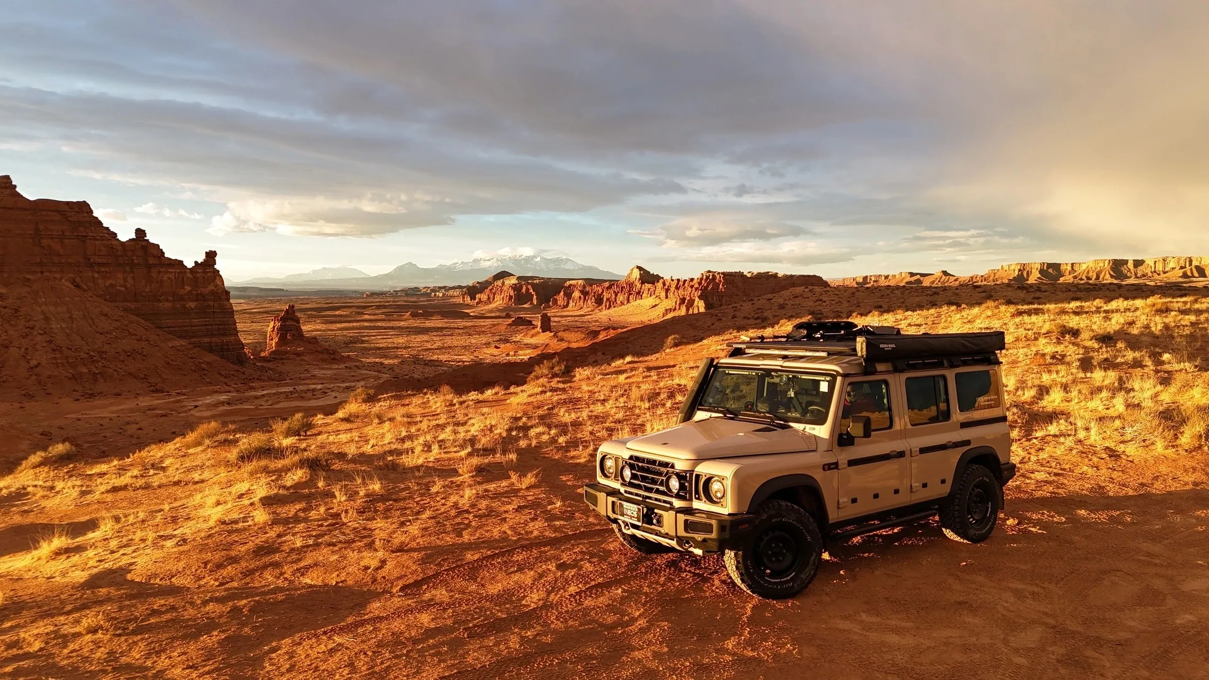 4x4 on a desert rim lit gold at sunrise