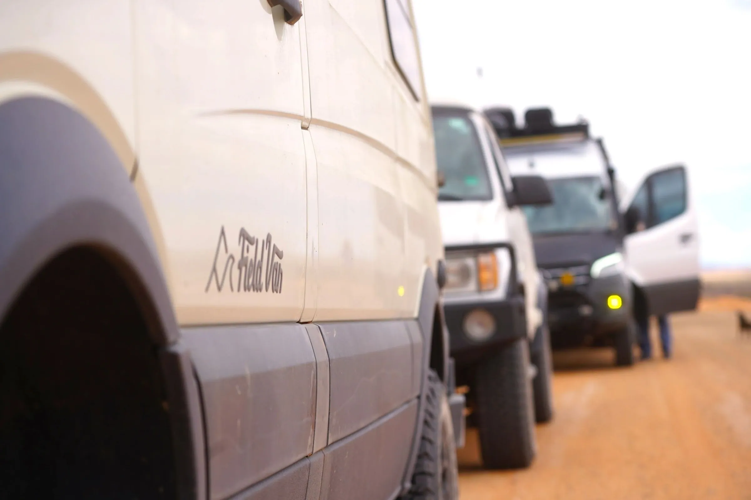 Close view of a Field Van camper van in a line of vans in the desert