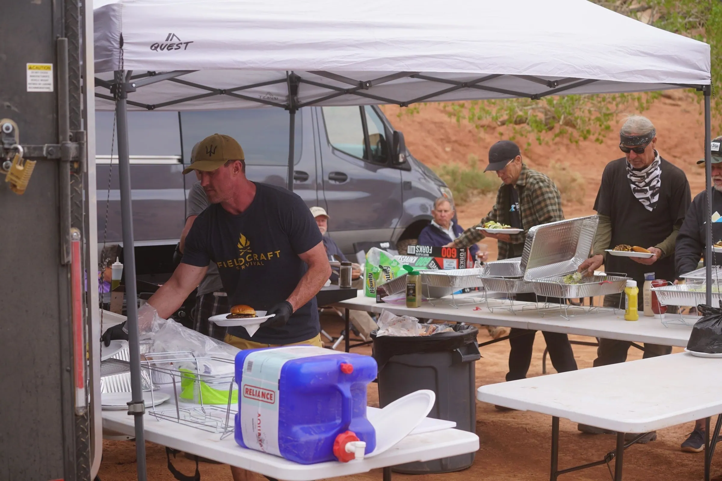 Cook preparing a meal at the camp kitchen table