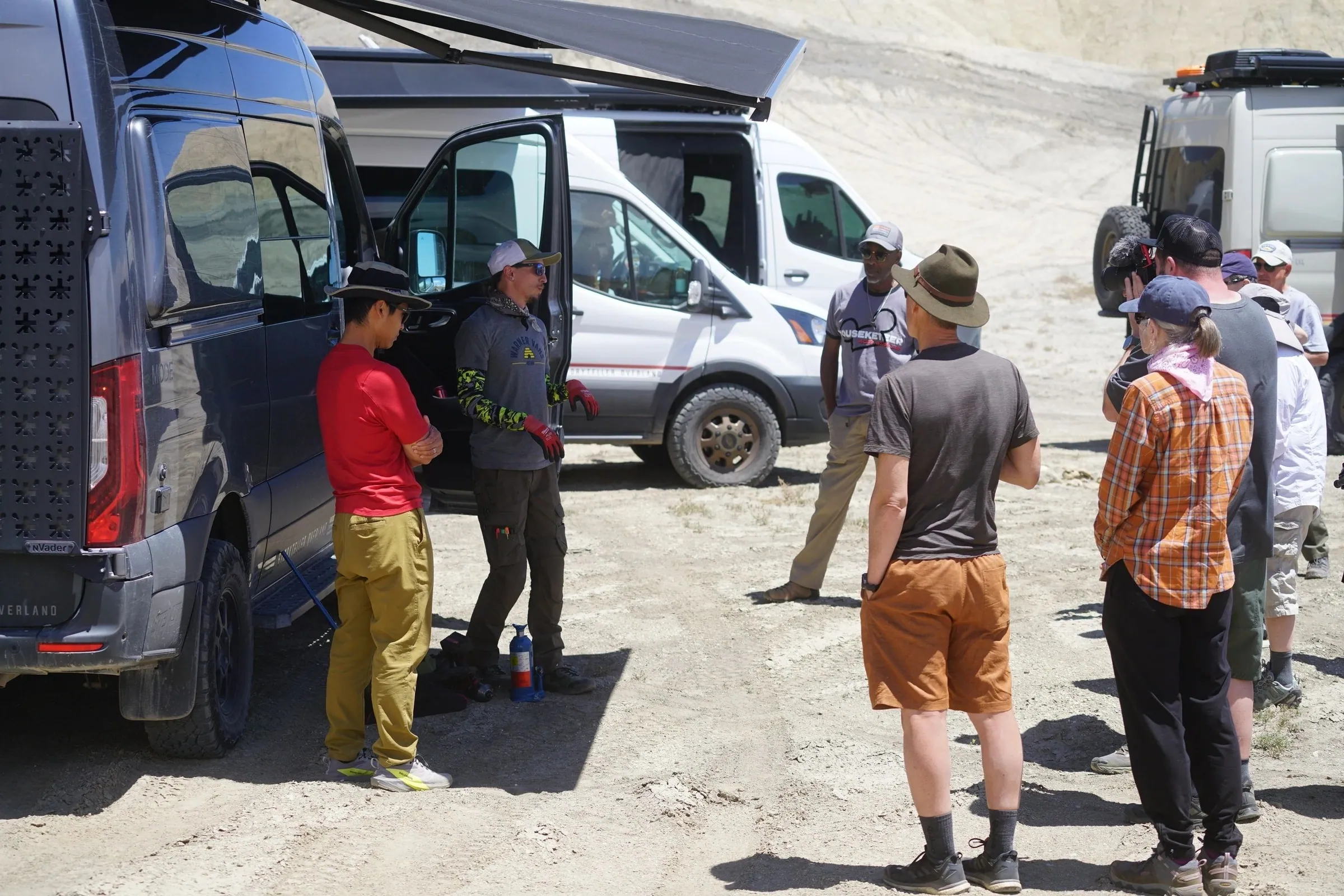 Guests talking beside open camper vans